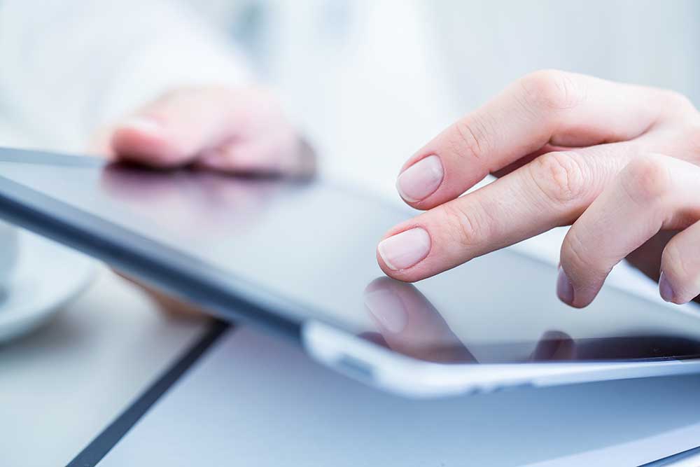 Hands using a tablet for scheduling